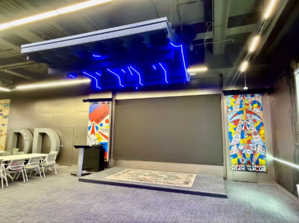 Event area with blue neon ceiling lighting, DD lettering and pop-art panels reading Always To Create High Value